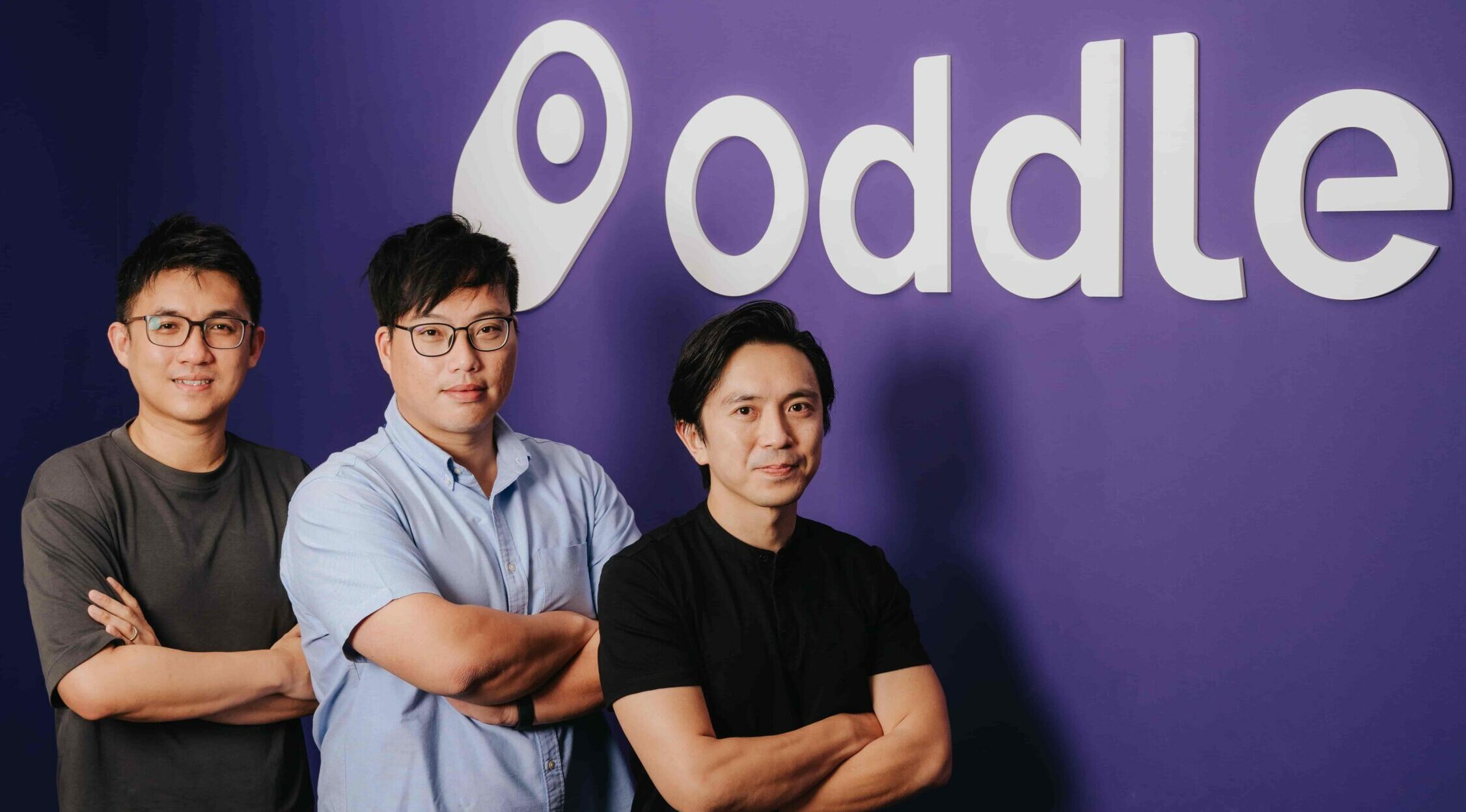 Photoshoot Image of Oddle's Founders Standing in front of a Oddle Logo