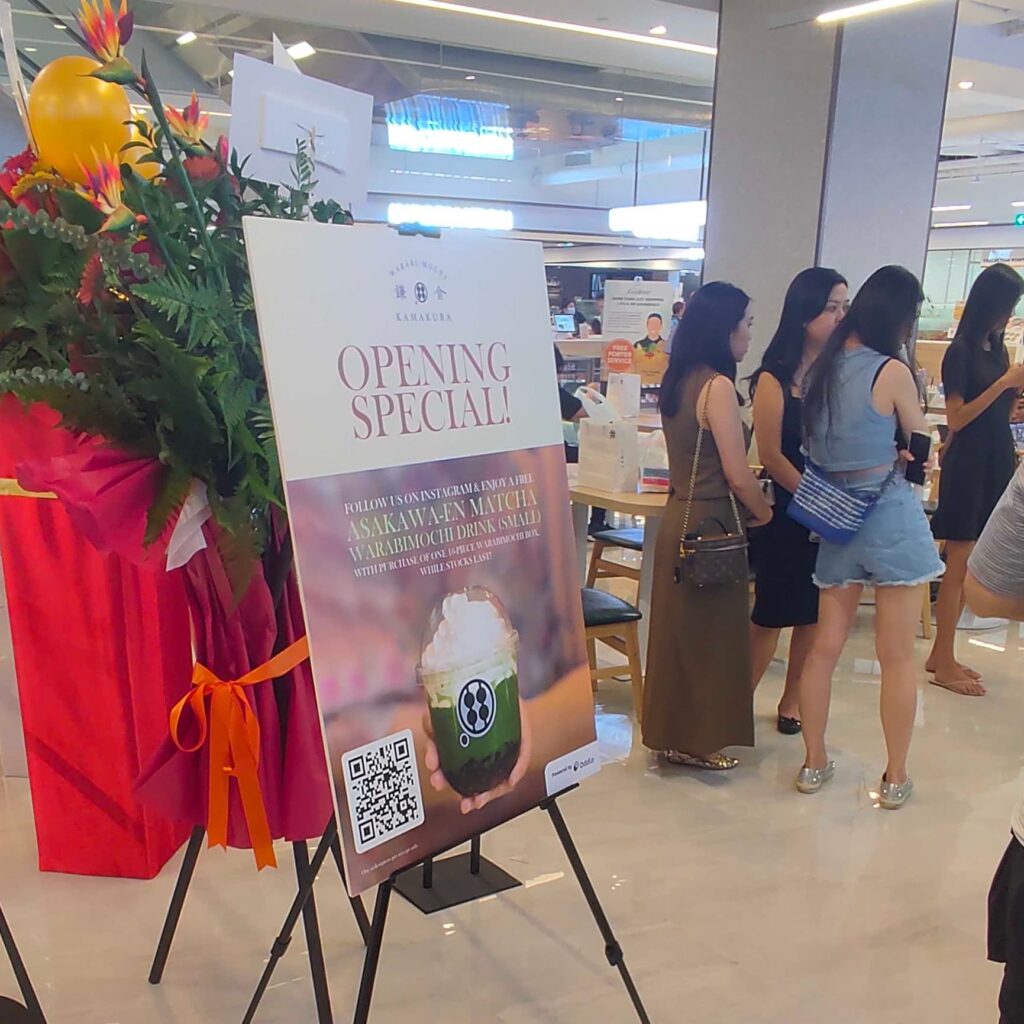 Standee displaying the store opening promotion via a Redeemables QR code